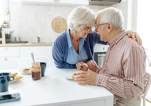 a senior woman placing a comforting arm around her husband